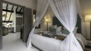 A bedroom with a four-poster bed, a bedside table, a lamp, and a nightstand. - The Villa Bentota by KK Collection (Bentota)