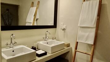 A bathroom with two sinks, a mirror, and a wooden ladder.