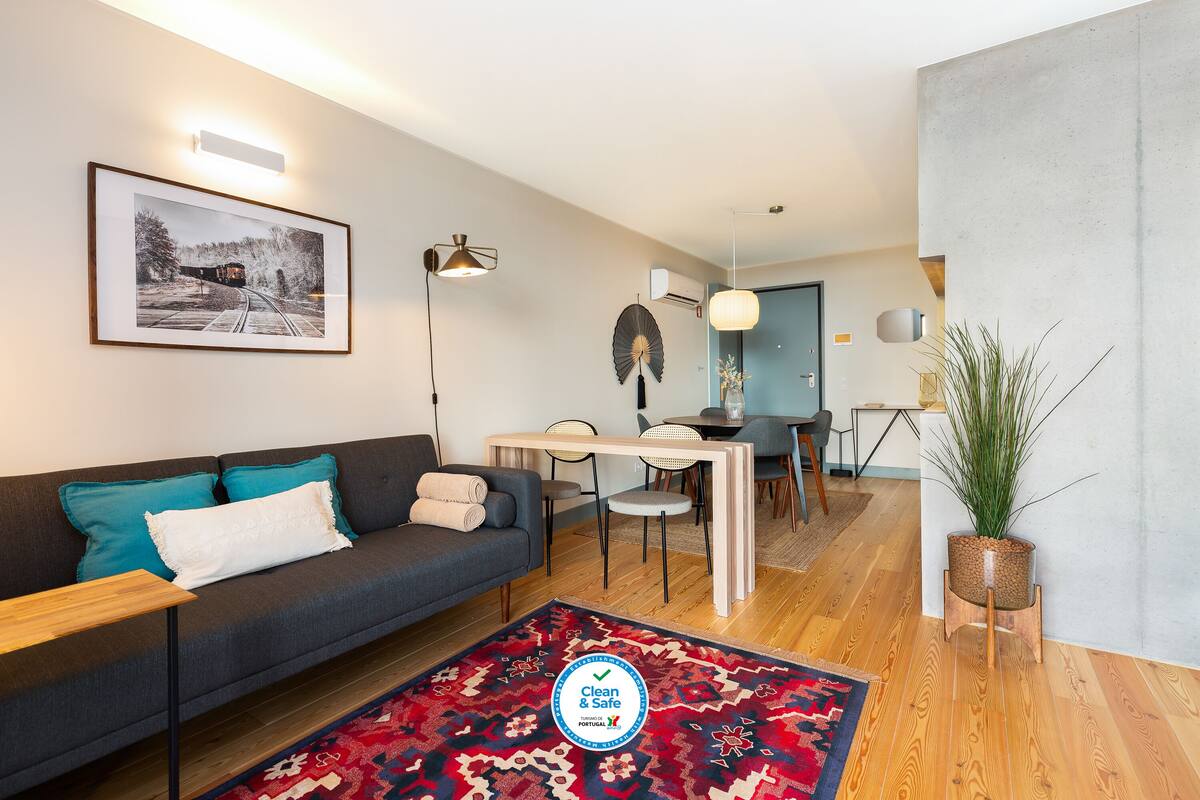 Un salon moderne avec un canapé, une table à manger et une plante en pot.