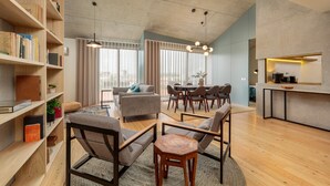 A modern living room with a sofa, chairs, a coffee table, and a bookshelf. - Feel Porto Corporate Housing Campanhã (Porto)