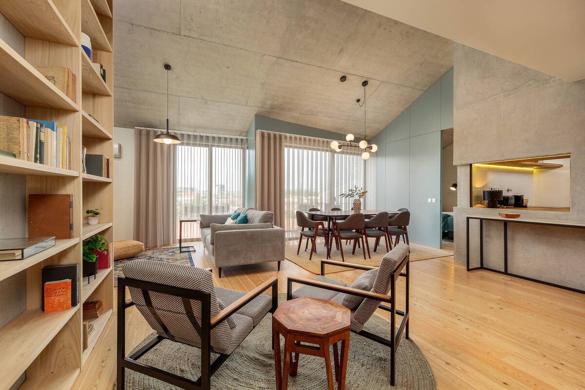 Un salon moderne comprenant un canapé, des fauteuils, une table basse et une bibliothèque.