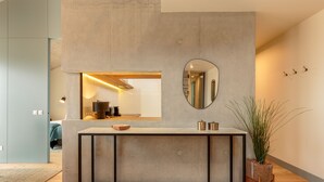 A modern kitchen with a concrete countertop, a round mirror, and a potted plant. - Feel Porto Corporate Housing Campanhã (Porto)