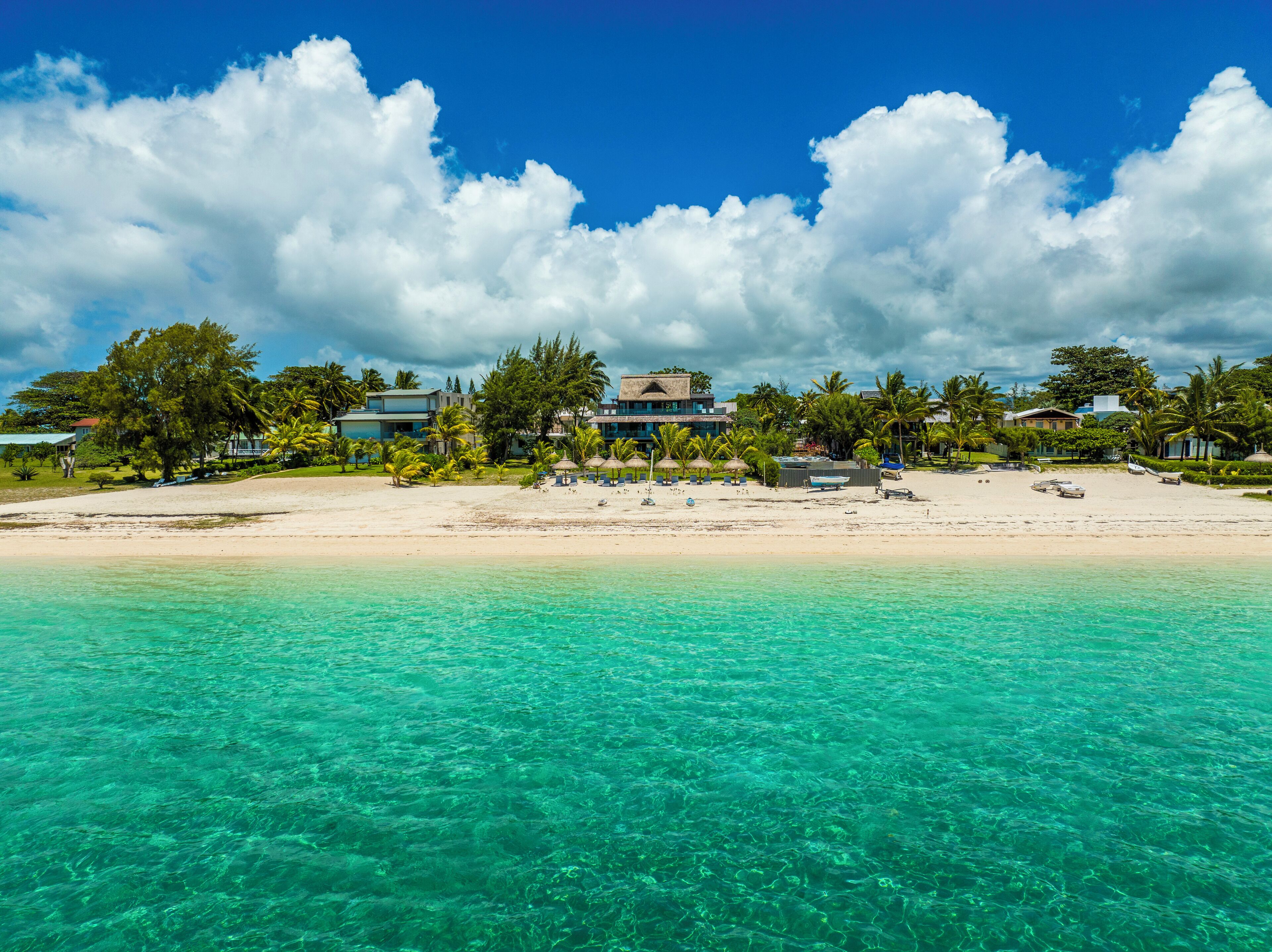 En la playa, playa de arena blanca, camastros y sombrillas 