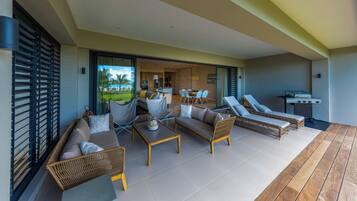 A spacious outdoor living area with a sofa, chairs, and a grill.