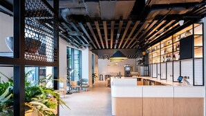 Een moderne keuken met een centraal eiland, houten kastjes en een hanglamp.