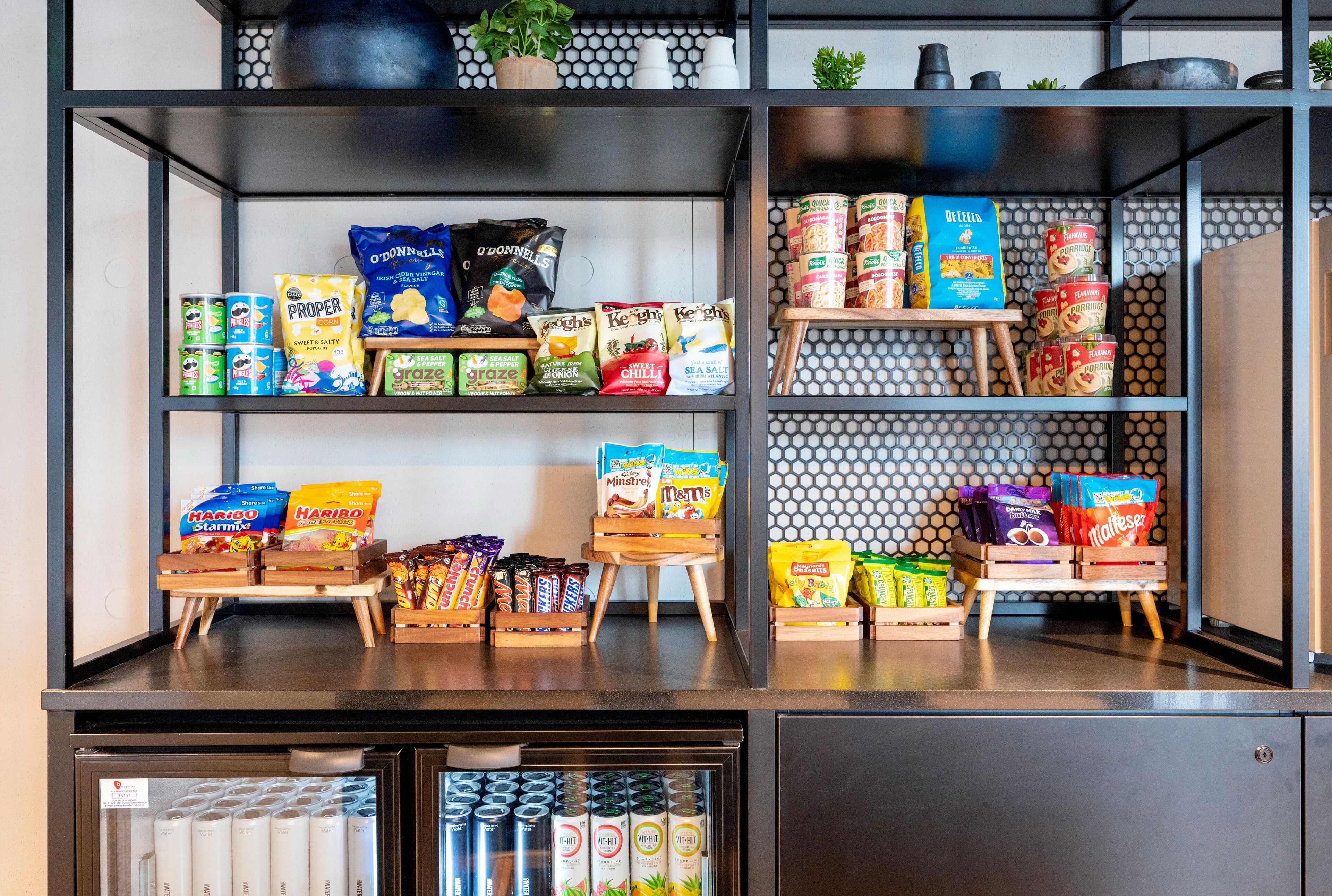 A snack display with various packaged foods and a refrigerated section below.