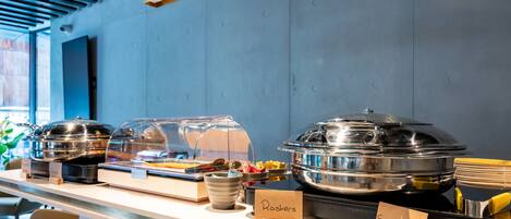 A buffet counter with labeled containers for Rishers and Sausages.