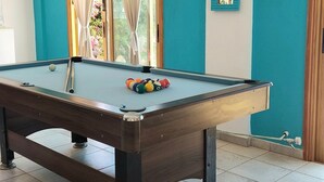 A pool table with balls, a mirror, and curtains in a room with teal walls. - Remarkable 2-bed Villa in Protaras (Paralimni)