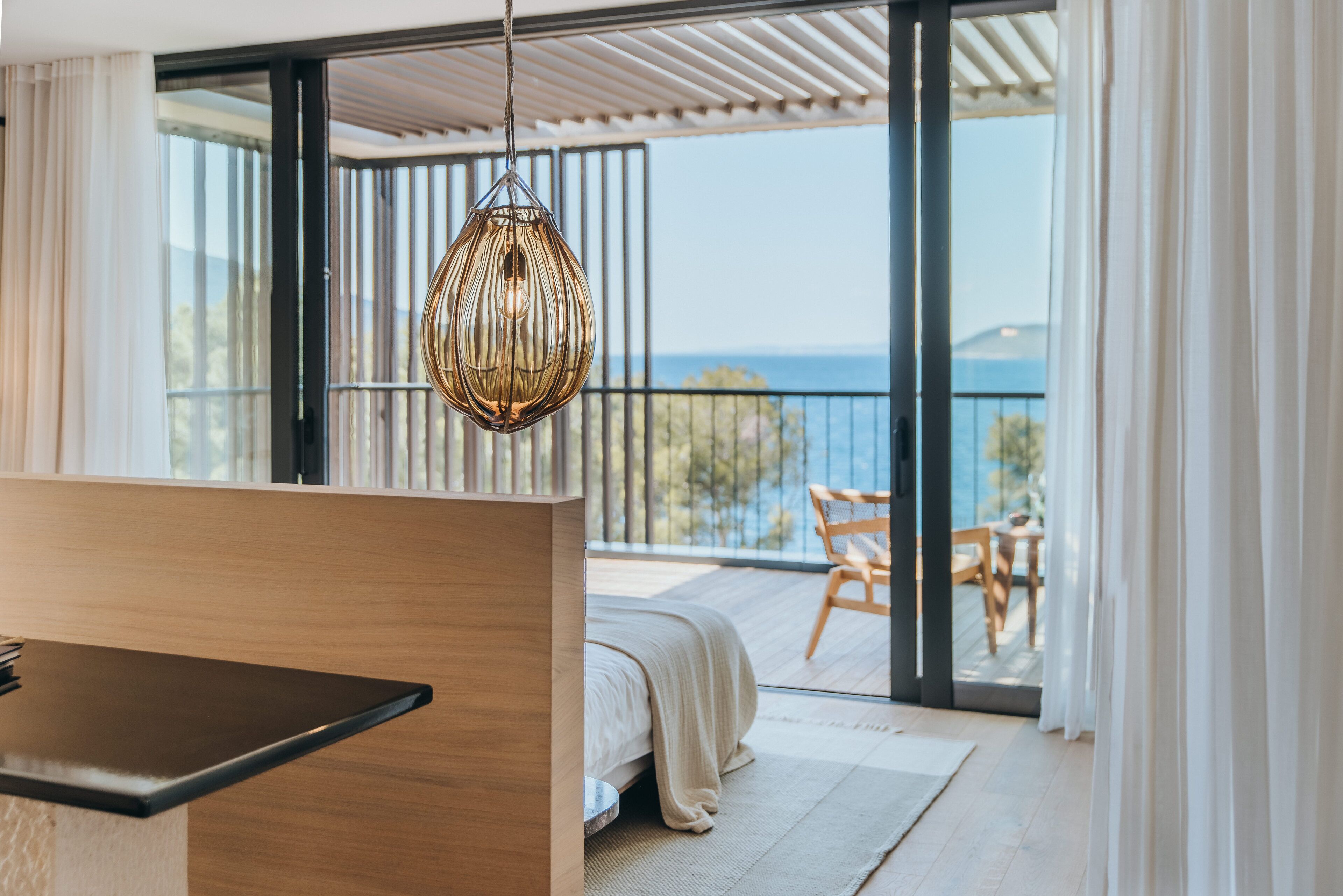 A modern bedroom with a large sliding glass door leading to a balcony.