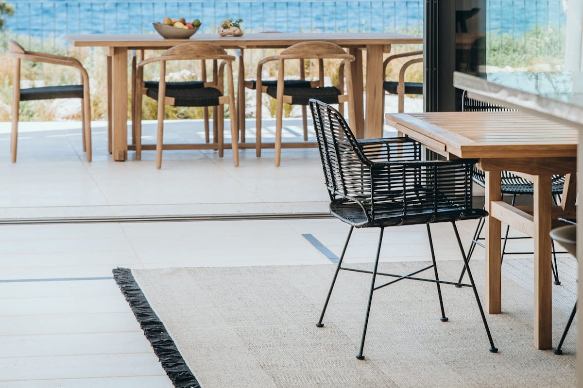 An outdoor dining area with a view of the sea and mountains.