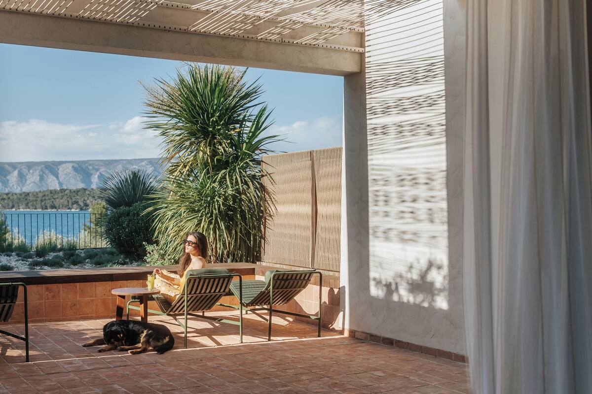 A balcony with a bed, a table, and a chair.
