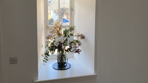 A window with a white interior and a vase of flowers on a windowsill. - Flemings Yard - Fantastic Town House in Anstruther (Anstruther)