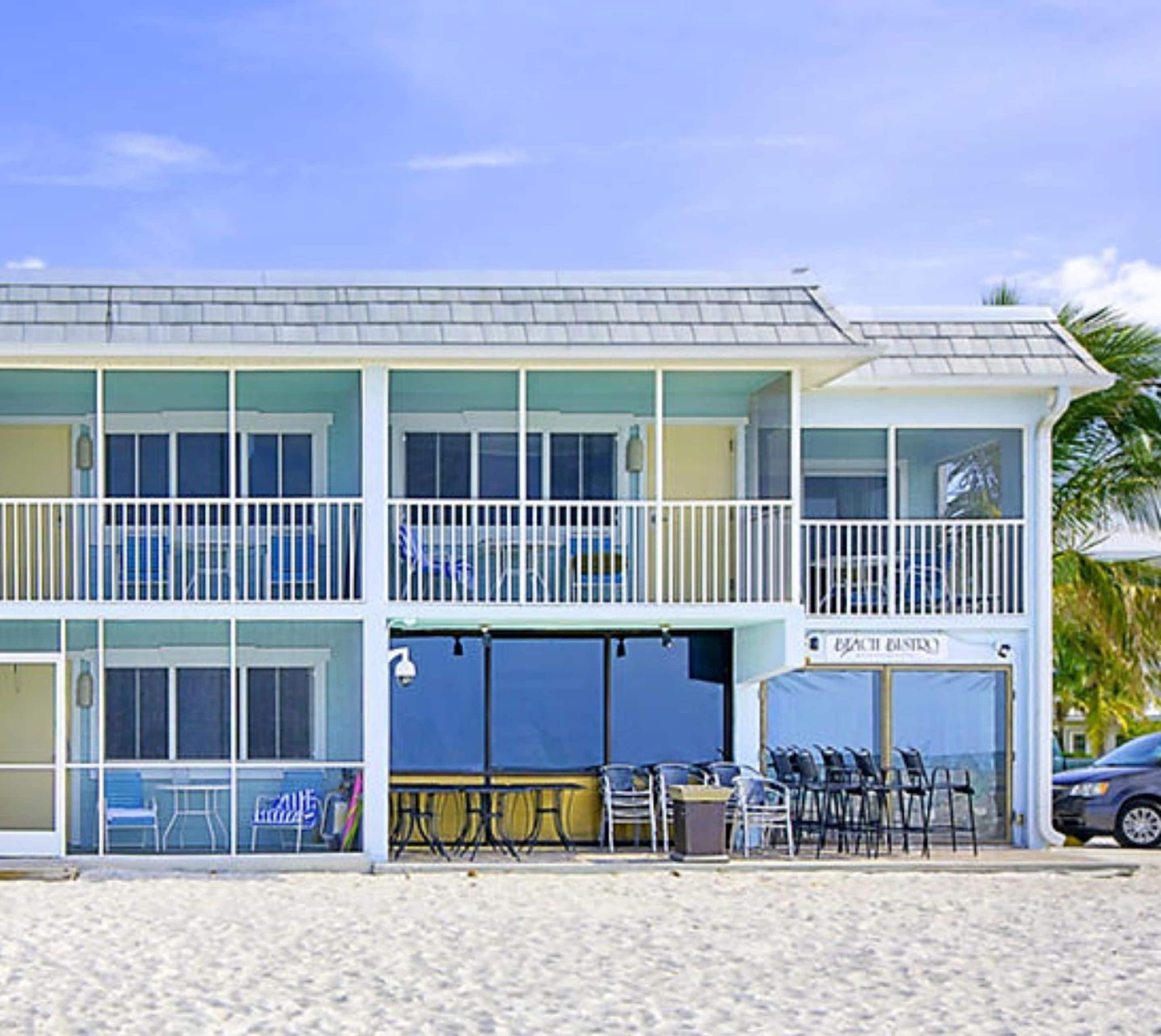 A beachfront building with a balcony, outdoor seating, and a sign for 'Eagle's Bistro'.