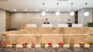 A reception area with marble counters, a marble floor, and hanging pendant lights. - Greentree Eastern Tianjin Dongli Development Zone Xinli Metro Station Hotel (Tianjin)