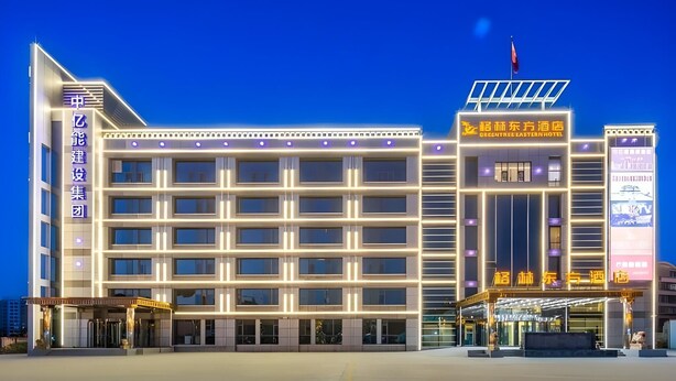 A modern hotel with multiple floors, a prominent entrance, and illuminated signage. - Greentree Eastern Tianjin Dongli Development Zone Xinli Metro Station Hotel (Tianjin)