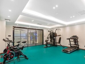 Ett träningscenter med träningsutrustning, ett löpband och en massagefåtölj.