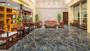 A lobby with marble flooring, wooden furniture, and potted plants. - Greentree Eastern Tianjin Dongli Development Zone Xinli Metro Station Hotel (Tianjin)