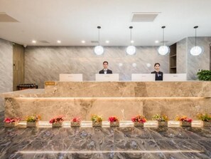 A reception area with marble counters, a marble floor, and hanging pendant lights. - Greentree Eastern Tianjin Dongli Development Zone Xinli Metro Station Hotel (Tianjin)