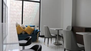 A modern interior with a sofa, chairs, and a dining table.