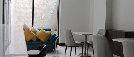 A modern interior with a sofa, chairs, and a dining table.