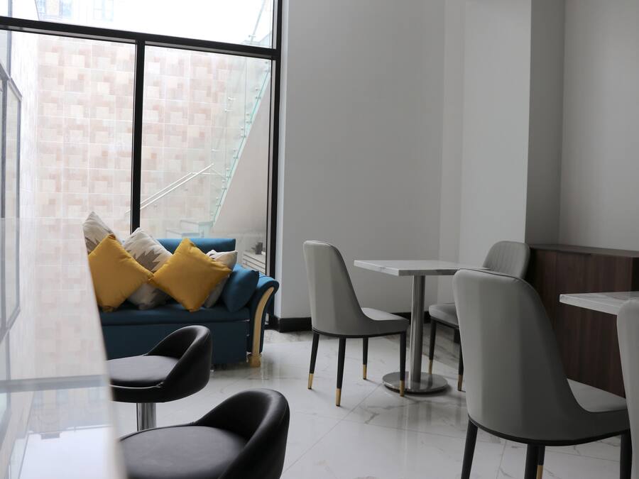 A modern interior with a sofa, chairs, and a dining table.