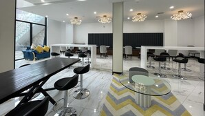 A modern conference room with a large table, multiple chairs, and a glass coffee table. - Liberty View Brooklyn hotel (Brooklyn)