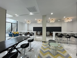 A modern conference room with a large table, multiple chairs, and a glass coffee table.