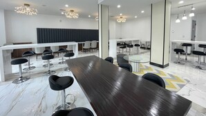 A modern conference room with a long table, multiple chairs, and a white reception desk. - Liberty View Brooklyn hotel (Brooklyn)