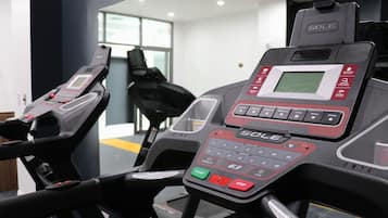 A gym with treadmills and a digital display.