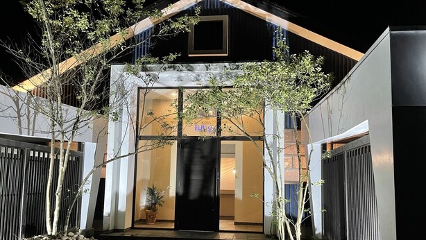 A modern hotel entrance with a glass door, a small garden area with rocks, and a pathway leading to the door. - HOTEL Fuuga Luxury Resort - Adults Only (Maizuru)