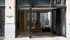 A modern building entrance with a sign for 'Balconies' and a parking area. - 60 Balconies Iconic (Madrid)