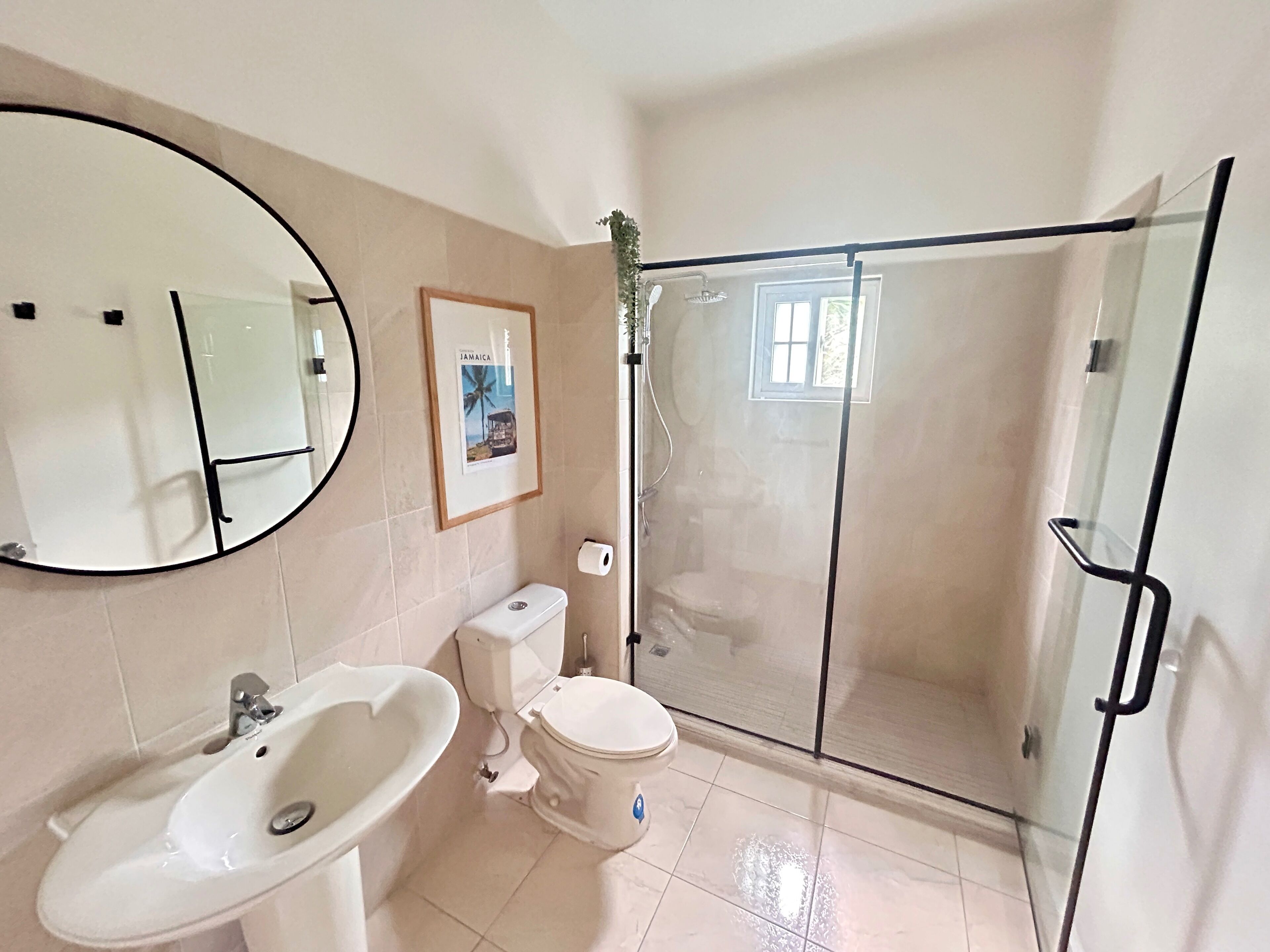 A bathroom with a sink, toilet, and glass-enclosed shower.
