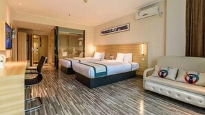 Une chambre d’hôtel avec un grand lit, un bureau, une chaise, un canapé et un miroir.