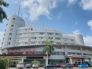 A multi-story building with a curved facade, large windows, and a prominent dome structure.