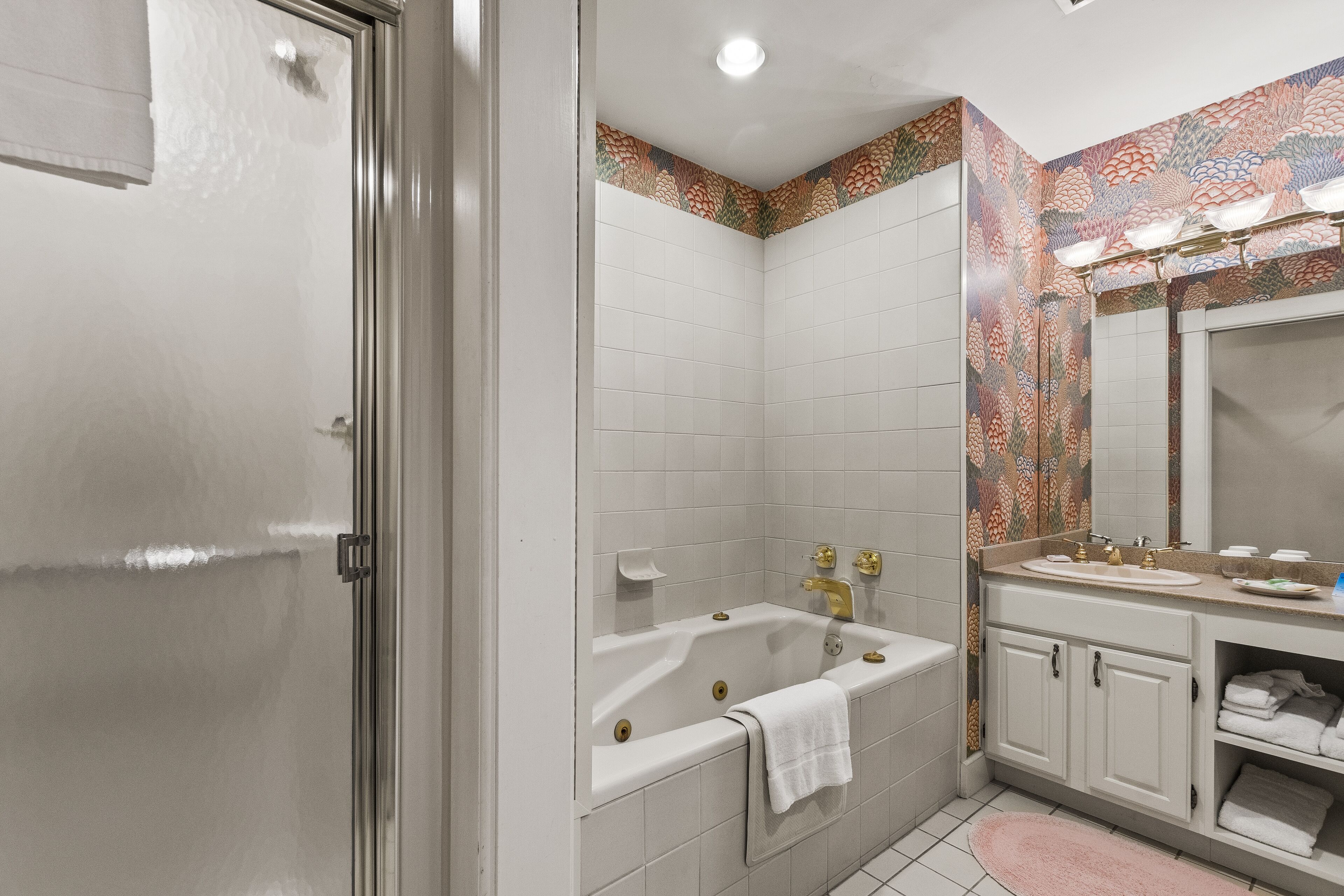 A bathroom with a bathtub, a sink, and a mirror.