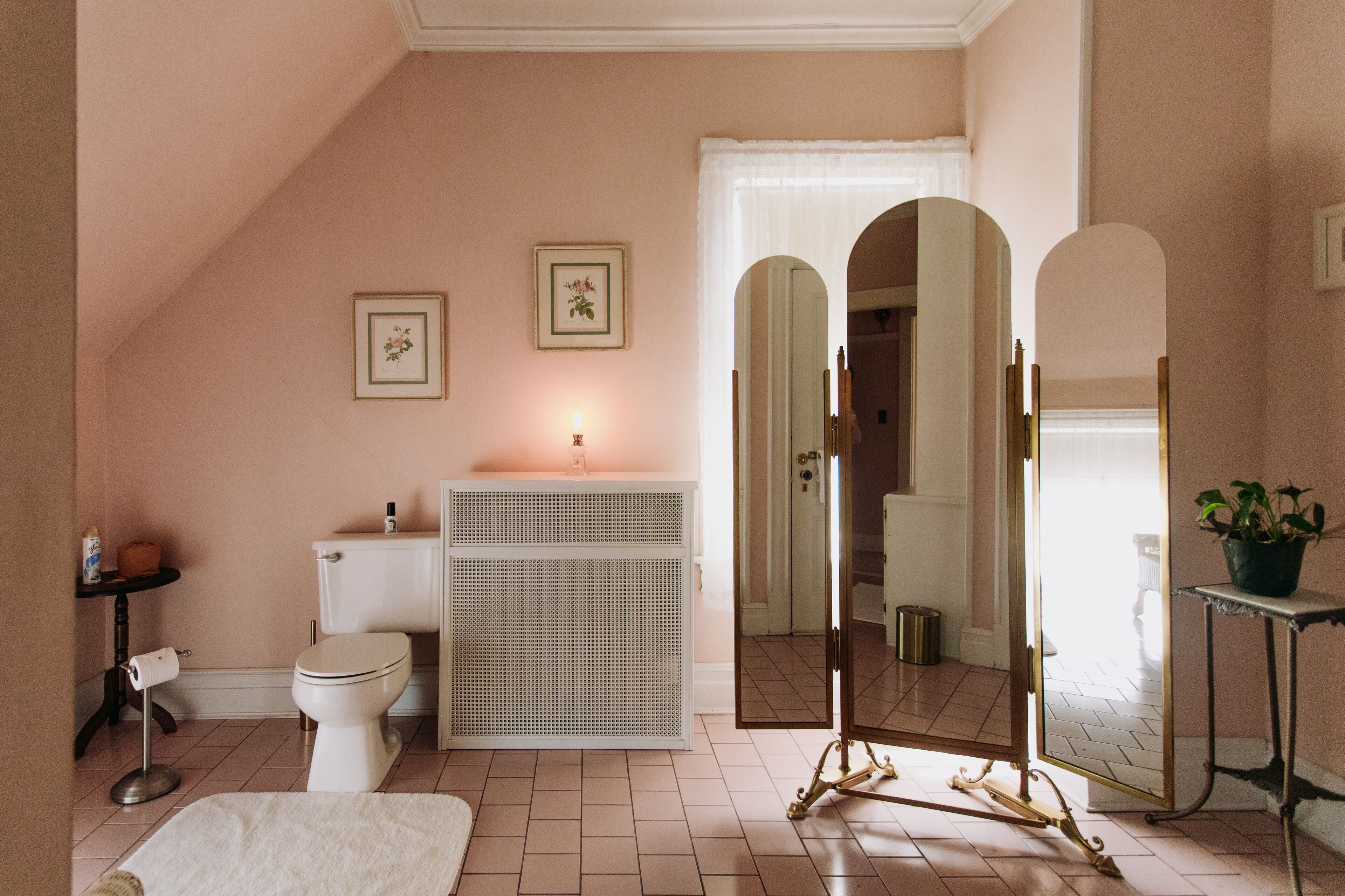 A bathroom with a toilet, bidet, vanity, and mirrors.