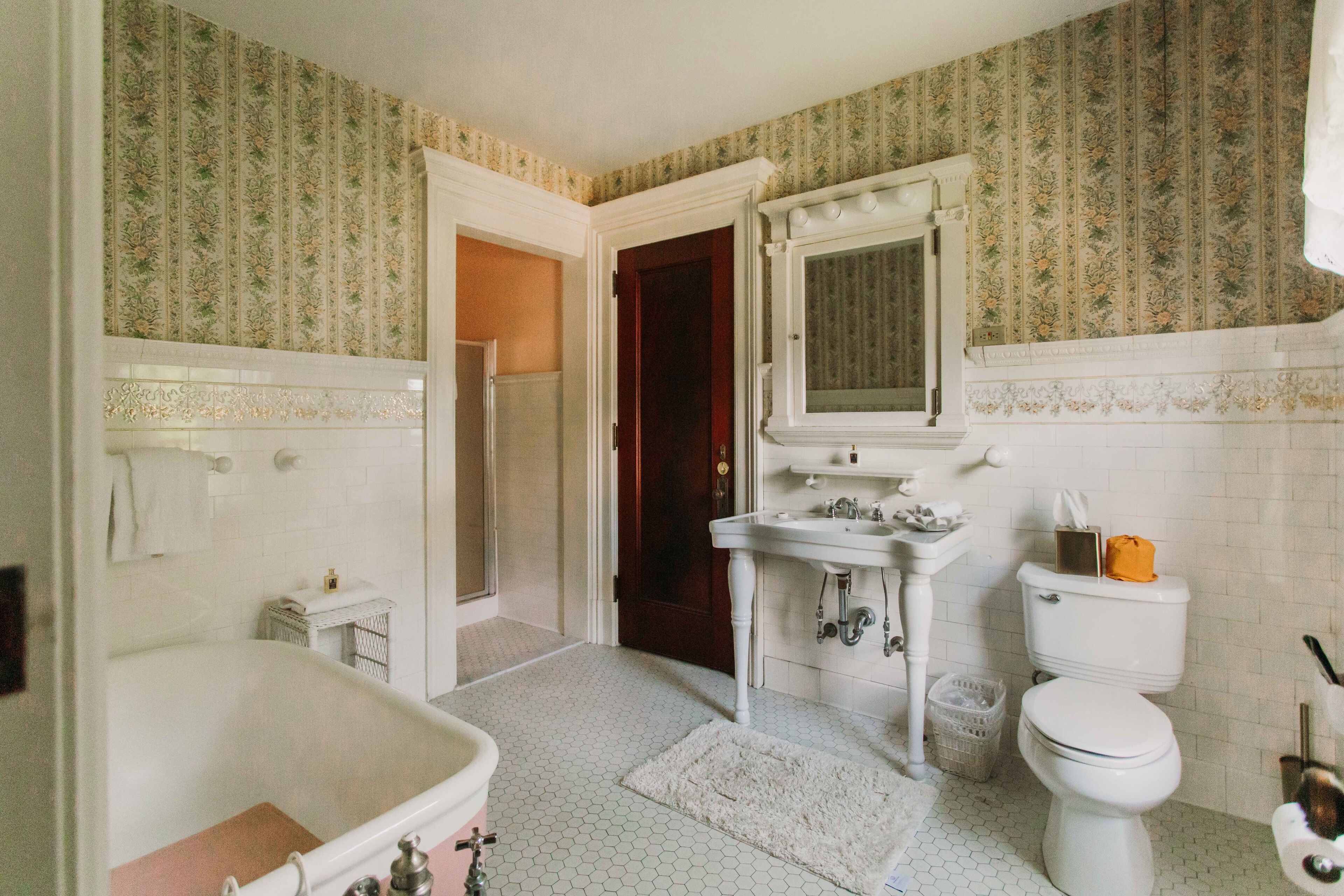 Un baño con bañera, lavamanos, inodoro y espejo.