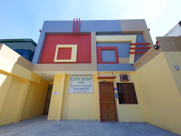 Un edificio con el letrero de City Stay Inns, que ofrece un ambiente limpio, acogedor y práctico.
