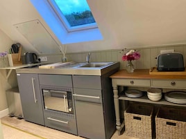 Una cocina moderna con tragaluz, electrodomésticos de acero inoxidable y encimera de madera.