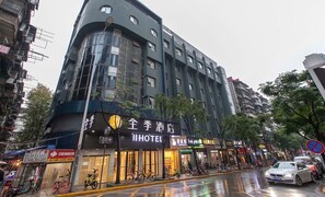A hotel with a modern facade, multiple floors, and a sign indicating it is a hotel. - Ji Hotel (Wuhan)