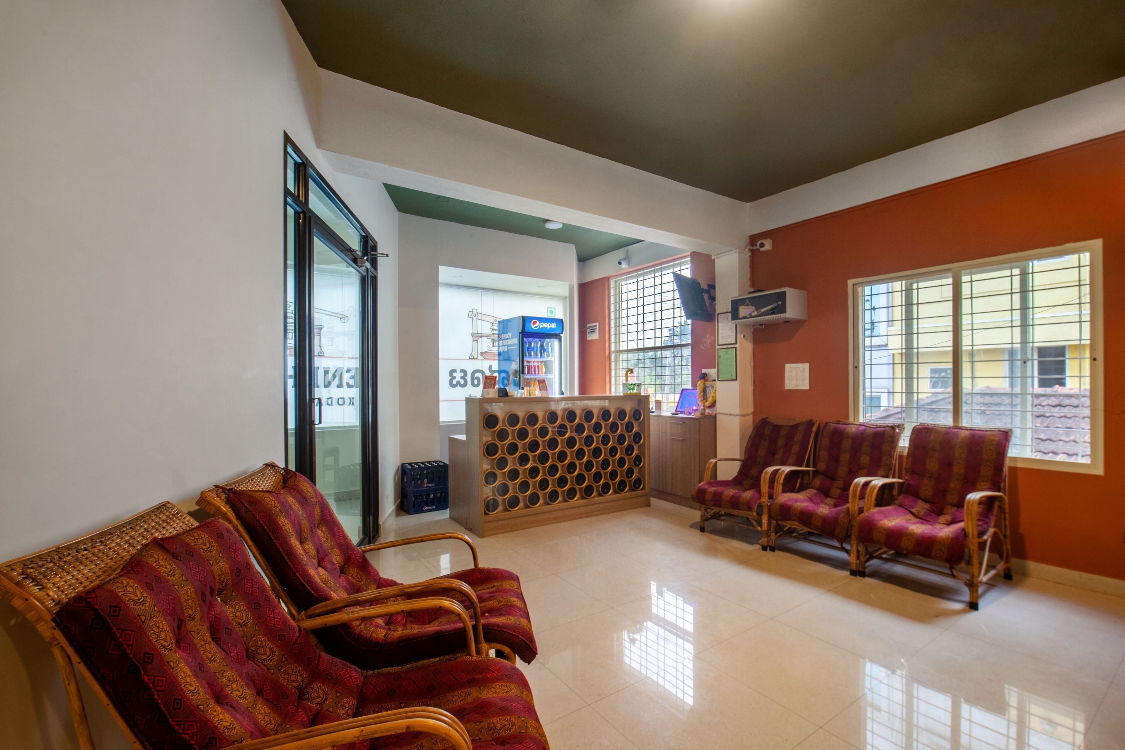 A waiting area with wicker chairs, a reception desk, and a large window.