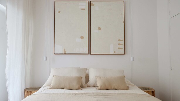 A minimalist bedroom with a large bed, two bedside tables, and abstract wall art. - Hestia at Arenales 1200 (Buenos Aires)