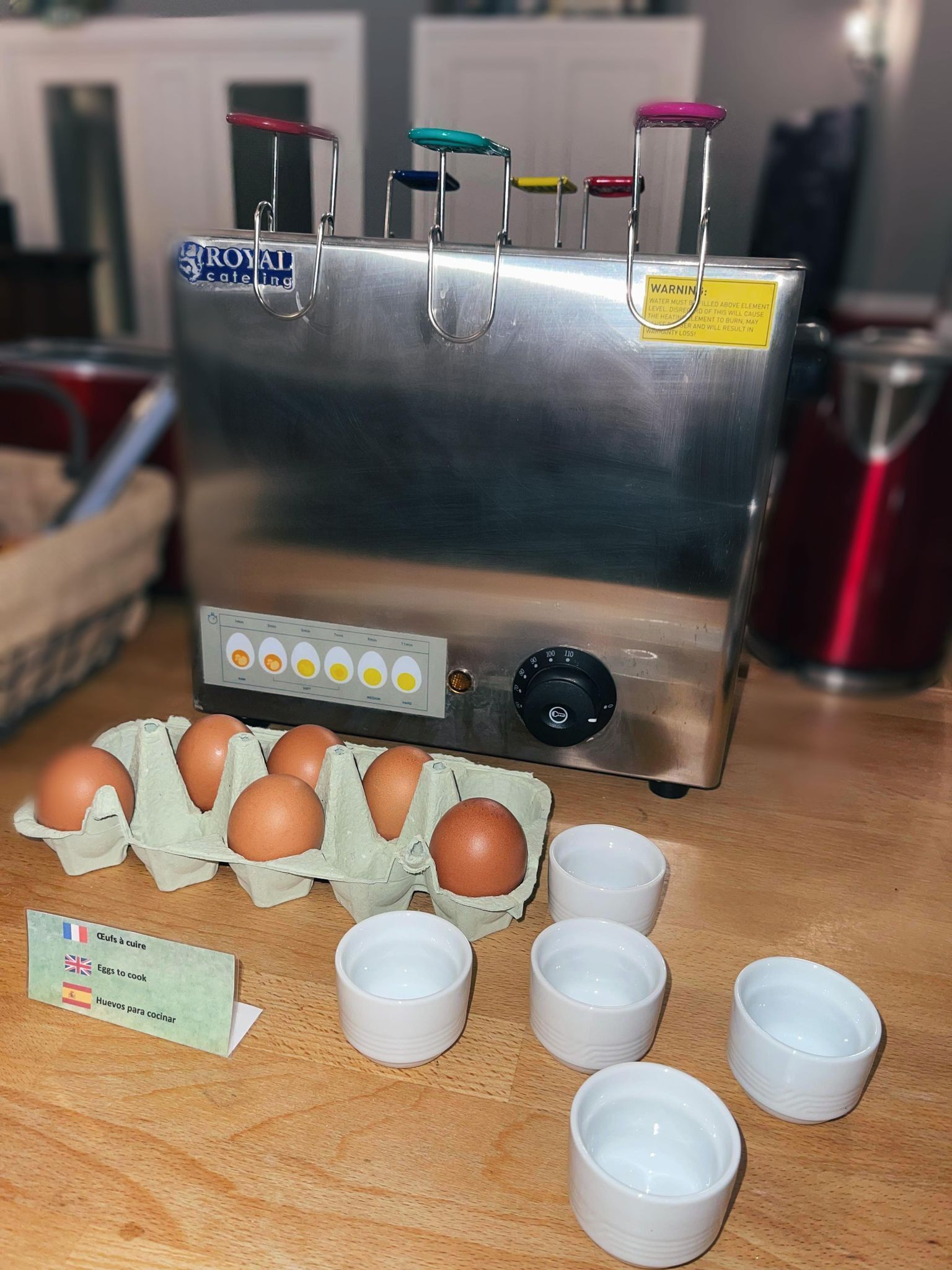 Una cocina con electrodoméstico de acero inoxidable, huevos y tazas.