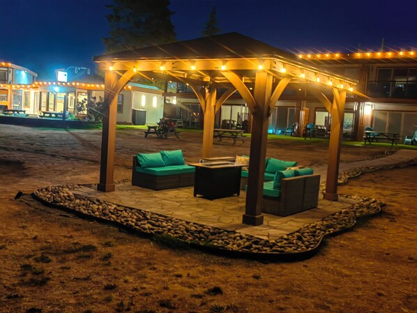 An outdoor patio area with a covered seating arrangement and a stone pathway.
