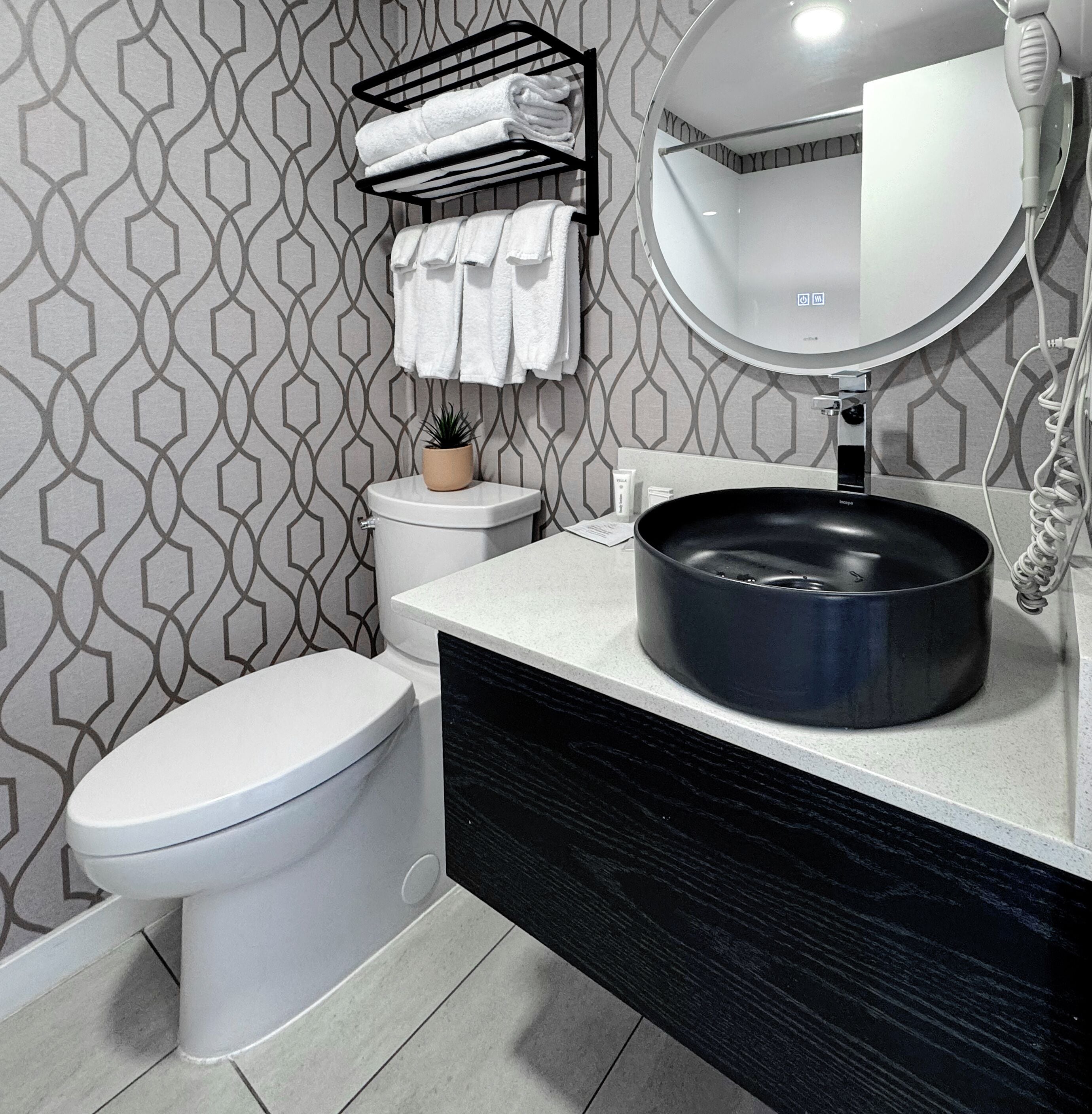 A modern bathroom with a toilet, sink, and towel rack.