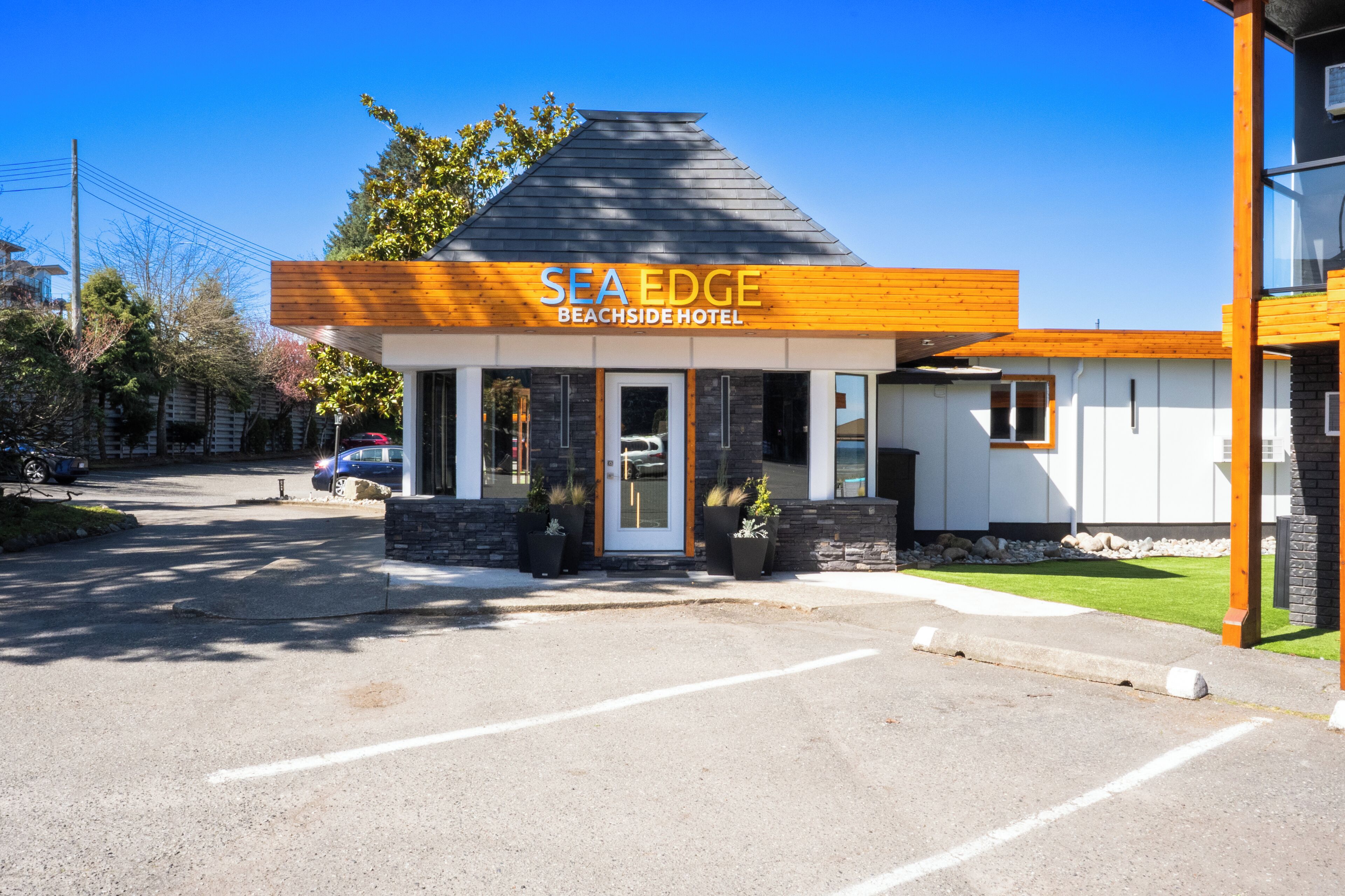 A modern hotel with a prominent sign reading 'SEA EDGE BEACHSIDE HOTEL.'