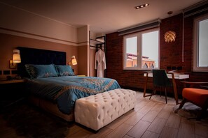 A bedroom with a large bed, bedside lamps, a desk, and a chair. - Hotel Palmera Dorada (Santiago Atitlán)