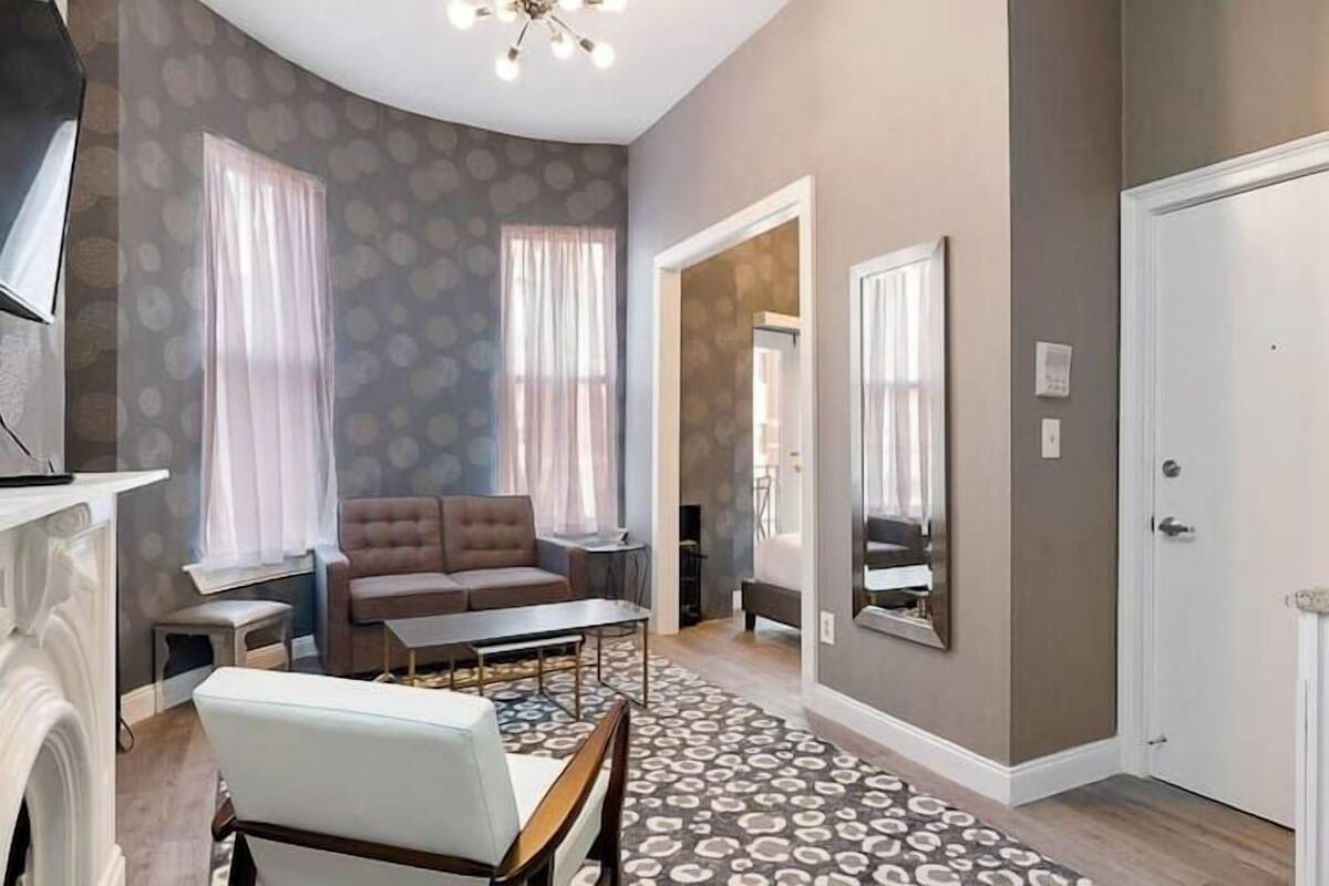 A modern living room with a sofa, coffee table, and a patterned rug.