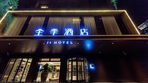 A hotel entrance with a modern design, featuring a prominent sign with Chinese characters and the word "HOTEL" in English. - Ji Hotel (Lanzhou)