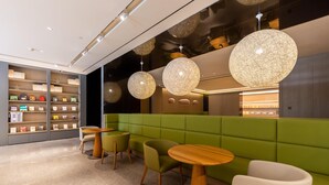 A modern interior with green seating, wooden tables, and pendant lighting. - Ji Hotel (Lanzhou)
